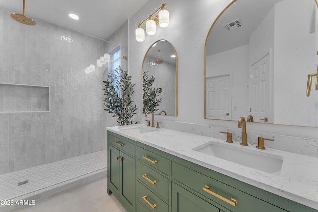 bathroom with vanity, tile patterned flooring, and a tile shower