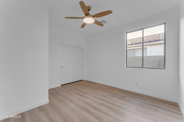 spare room with ceiling fan and light wood-type flooring