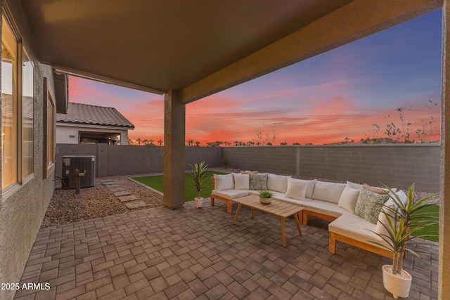 patio terrace at dusk with outdoor lounge area and cooling unit