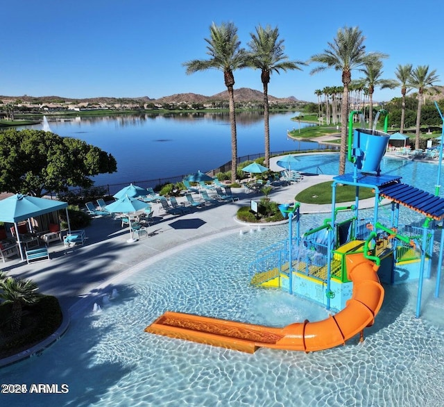 view of pool featuring a water and mountain view and a playground