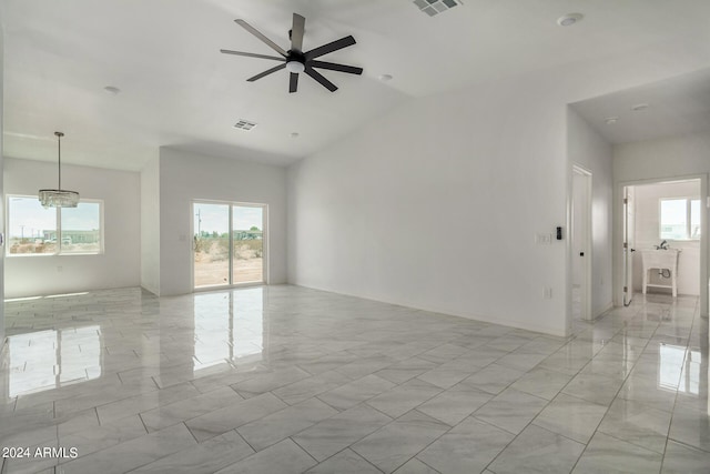 empty room with ceiling fan, light tile patterned floors, vaulted ceiling, and a healthy amount of sunlight