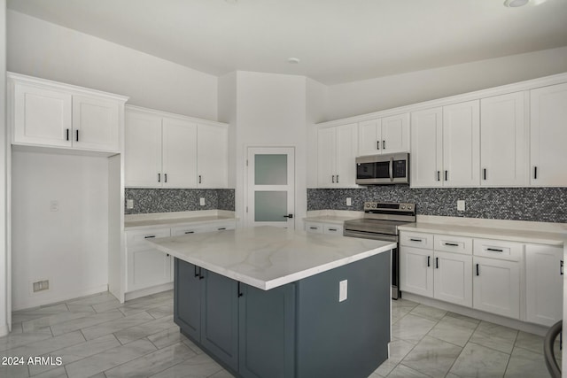 kitchen with backsplash, electric stove, a kitchen island, and white cabinetry