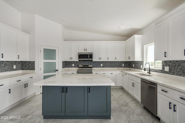 kitchen featuring stainless steel appliances, a center island, vaulted ceiling, tasteful backsplash, and sink