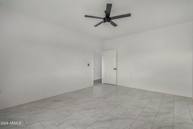 empty room with ceiling fan and light tile patterned floors