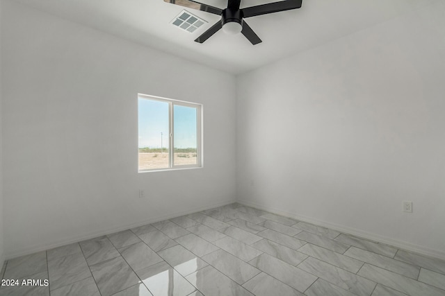 tiled spare room featuring ceiling fan