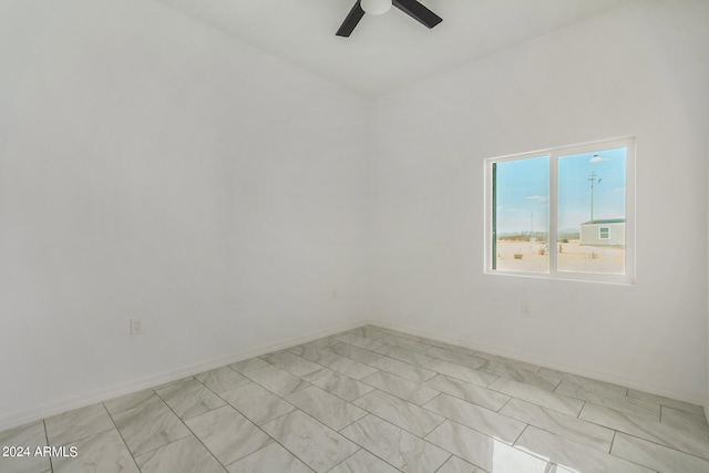 empty room with ceiling fan and light tile patterned floors