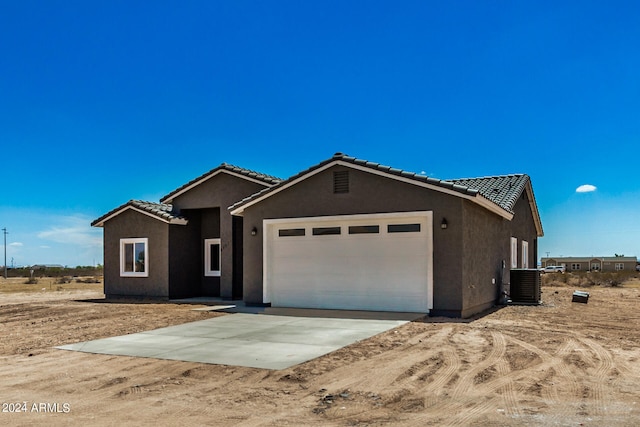 view of front of house with central AC and a garage