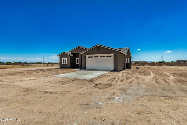 view of front of home with a garage and a rural view