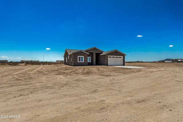 view of front facade featuring a rural view and a garage