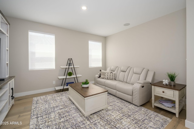 living room with recessed lighting, baseboards, and light wood-style flooring