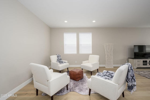 living area featuring recessed lighting, baseboards, and light wood-style flooring