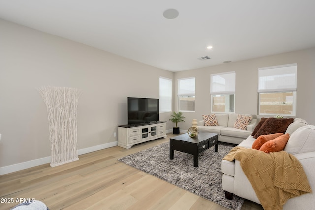 living area featuring light wood-style floors, baseboards, recessed lighting, and visible vents
