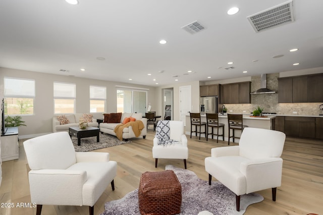 living room featuring visible vents, recessed lighting, and light wood-type flooring