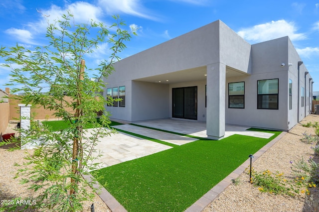 rear view of house with a patio area and stucco siding