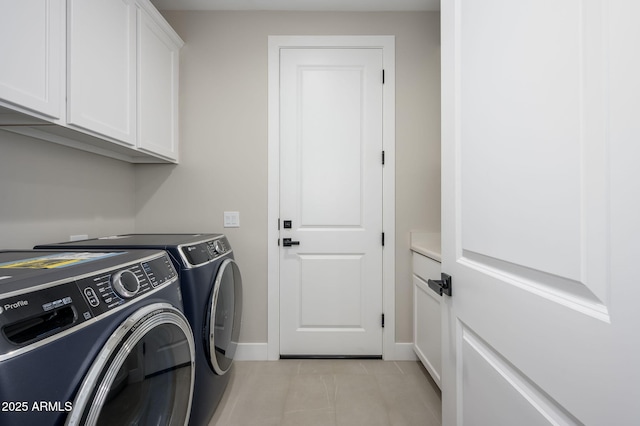 laundry room with cabinet space, light tile patterned flooring, baseboards, and washer and clothes dryer