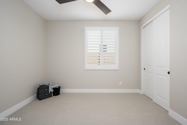 unfurnished bedroom featuring baseboards, ceiling fan, a closet, and carpet flooring