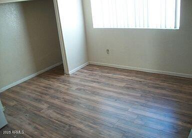 unfurnished bedroom featuring dark hardwood / wood-style floors and a closet