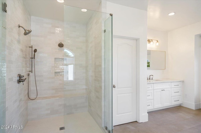 bathroom with vanity and tiled shower