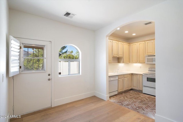 kitchen with white appliances, light brown cabinetry, and light wood-type flooring