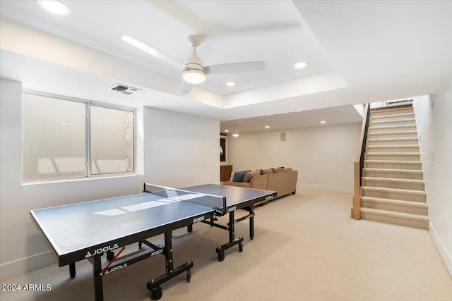 recreation room with a raised ceiling, carpet, and ceiling fan