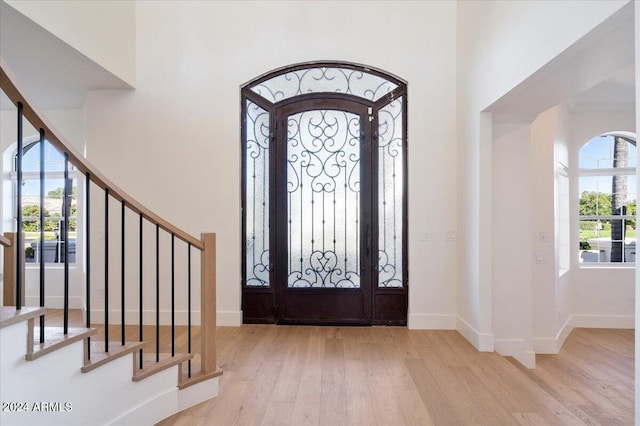 entrance foyer with a high ceiling and light wood-type flooring