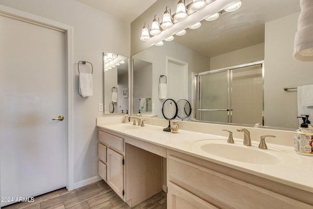 bathroom featuring vanity, an enclosed shower, and wood-type flooring