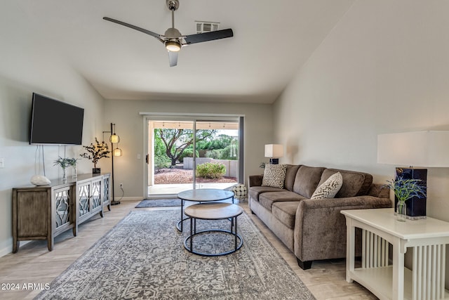 living room with ceiling fan, vaulted ceiling, and light hardwood / wood-style floors