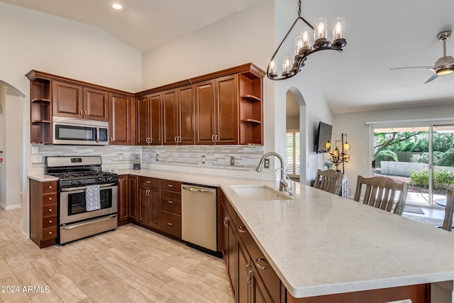 kitchen with stainless steel appliances, kitchen peninsula, and vaulted ceiling