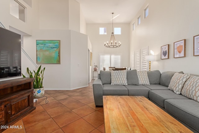 tiled living room featuring a high ceiling and a notable chandelier