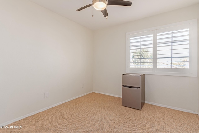 carpeted spare room with ceiling fan