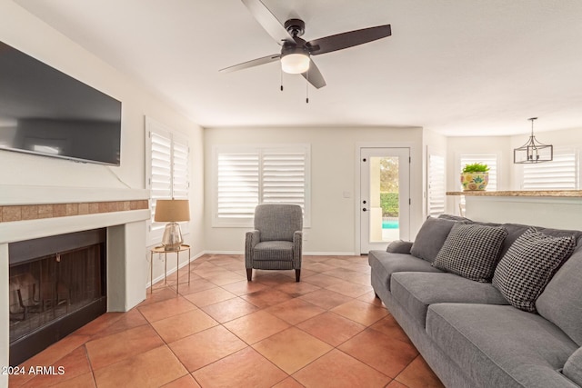 living room featuring light tile patterned floors and ceiling fan with notable chandelier