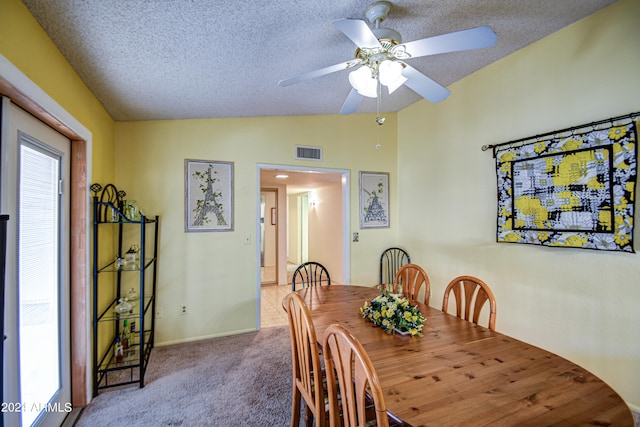 carpeted dining room with ceiling fan, vaulted ceiling, and a textured ceiling