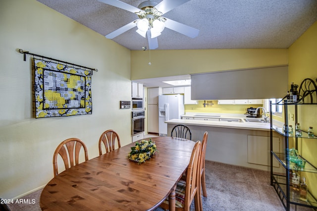 dining space with ceiling fan, a textured ceiling, light colored carpet, and lofted ceiling