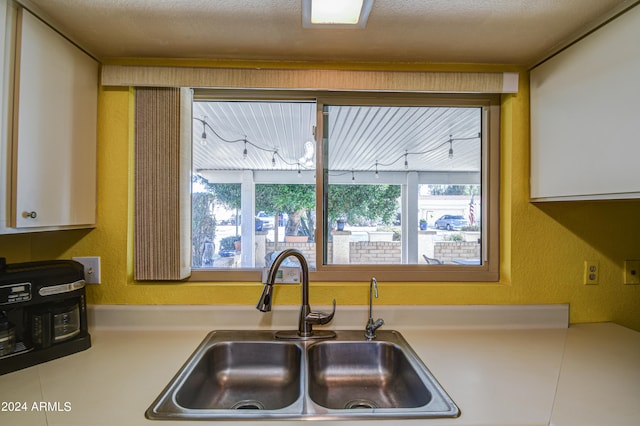 kitchen featuring sink and white cabinets