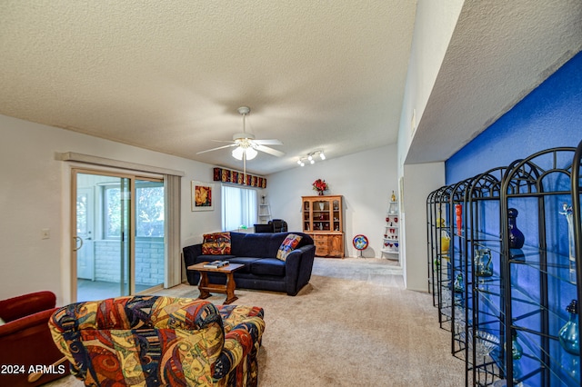 living room featuring a textured ceiling, carpet, and ceiling fan