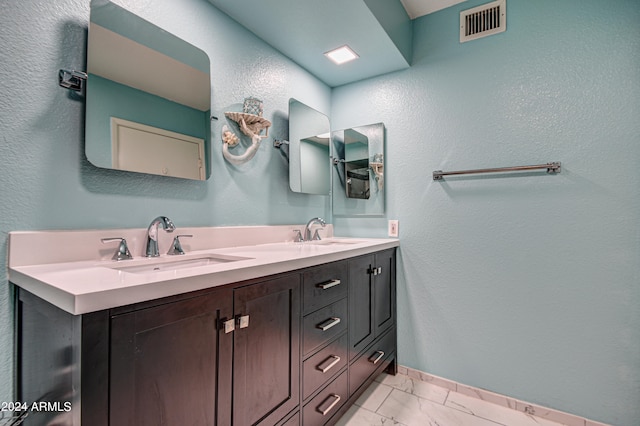 bathroom with vanity with extensive cabinet space, double sink, and tile floors