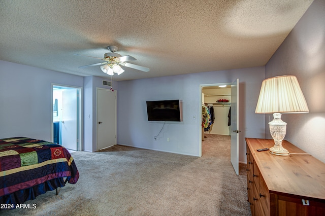 carpeted bedroom featuring ceiling fan, a closet, a textured ceiling, and a spacious closet