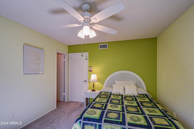 carpeted bedroom with a textured ceiling and ceiling fan