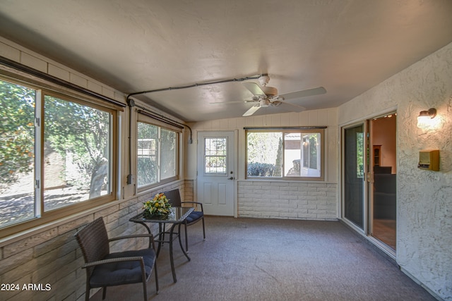 sunroom / solarium with ceiling fan and lofted ceiling