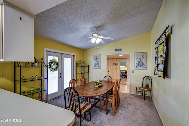 dining room with a textured ceiling, carpet floors, ceiling fan, and vaulted ceiling