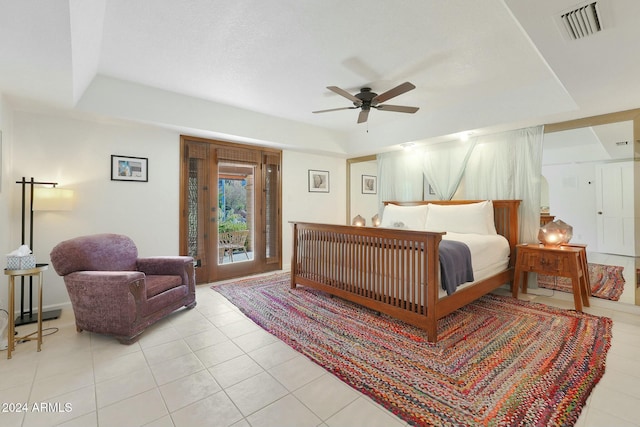 tiled bedroom with access to outside, a raised ceiling, and ceiling fan