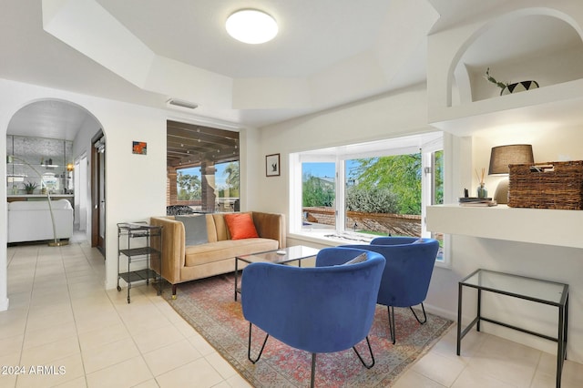 tiled living room featuring a tray ceiling