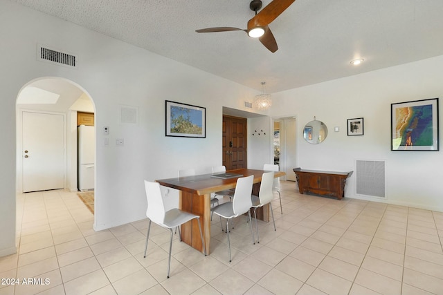 tiled dining room featuring a textured ceiling and ceiling fan