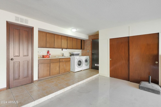 washroom featuring a textured ceiling, cabinets, independent washer and dryer, and sink