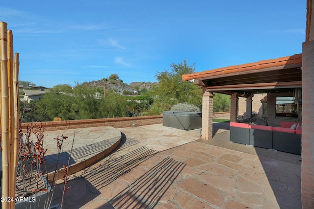 view of patio with a hot tub and an outdoor hangout area