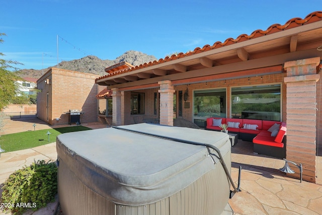 view of patio with a mountain view, area for grilling, an outdoor hangout area, and a hot tub