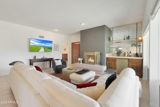 tiled living room with a fireplace and a textured ceiling