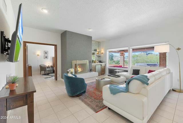 living room featuring a large fireplace, light tile patterned flooring, and a textured ceiling