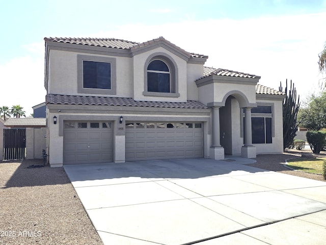 mediterranean / spanish home with a garage, a tile roof, driveway, and stucco siding