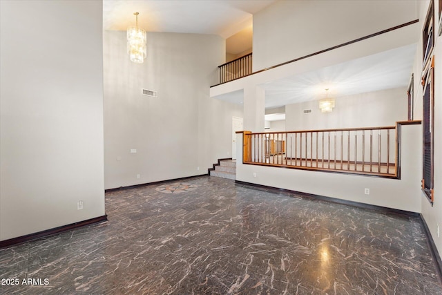 unfurnished room featuring visible vents, baseboards, marble finish floor, a high ceiling, and a chandelier